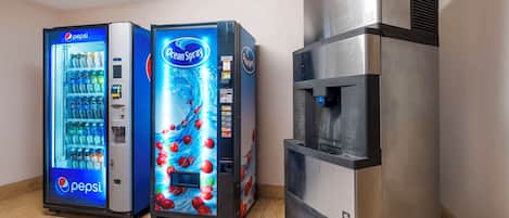 Dos máquinas expendedoras de bebidas, una de Pepsi y otra de Ocean Spray, y un dispensador de agua de acero inoxidable.