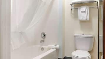 A bathroom with a bathtub, toilet, and towel rack.