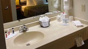 A hotel bathroom with a sink, mirror, towel rack, and a hairdryer mounted on the wall. - Super 8 by Wyndham Cresco IA (Cresco)