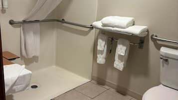 A bathroom with a shower, a toilet, and a towel rack.