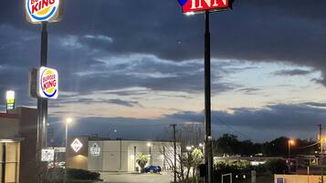 Un parking avec des panneaux indiquant la présence d’un restaurant Burger King et d’un autre appelé Texas Inn.