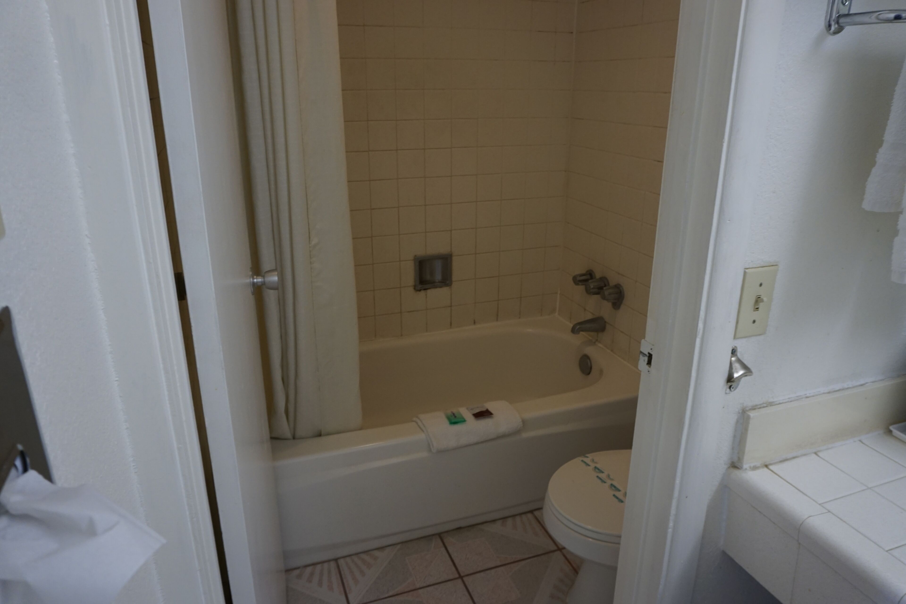 Un baño con bañera, inodoro y cortina de ducha.