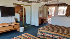 Une chambre d’hôtel avec deux lits, une télévision, un bureau et une chaise.