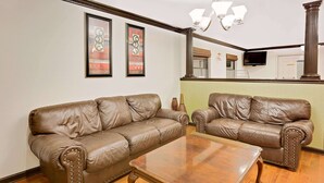Una sala de estar con dos sofás de cuero marrón y una mesa de centro de madera.