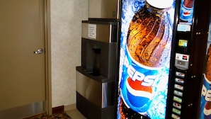 Un distributeur automatique orné du logo Pepsi, avec un distributeur d’eau à côté.