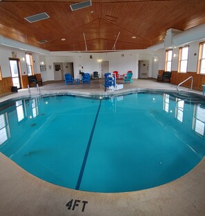 Una piscina techada, sillones reclinables de piscina