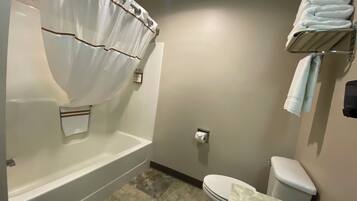 A bathroom with a bathtub, toilet, and towel rack.