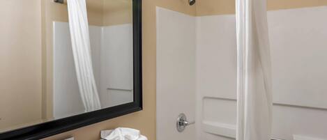 A bathroom with a bathtub, a toilet, a sink, and a mirror.