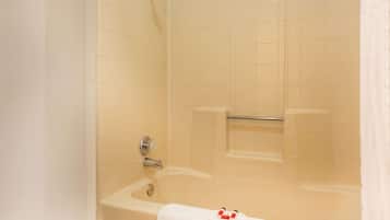 A bathroom with a bathtub, a showerhead, and a towel rack.