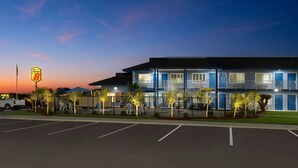 A motel with a two-story structure, a parking lot, and a Super 8 sign. - Super 8 by Wyndham Lindsay Olive Tree (Lindsay)