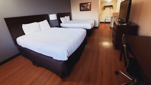 A hotel room with two beds, a desk, a chair, a TV, and a lamp. - Americas Best Value Inn Moline (Moline)