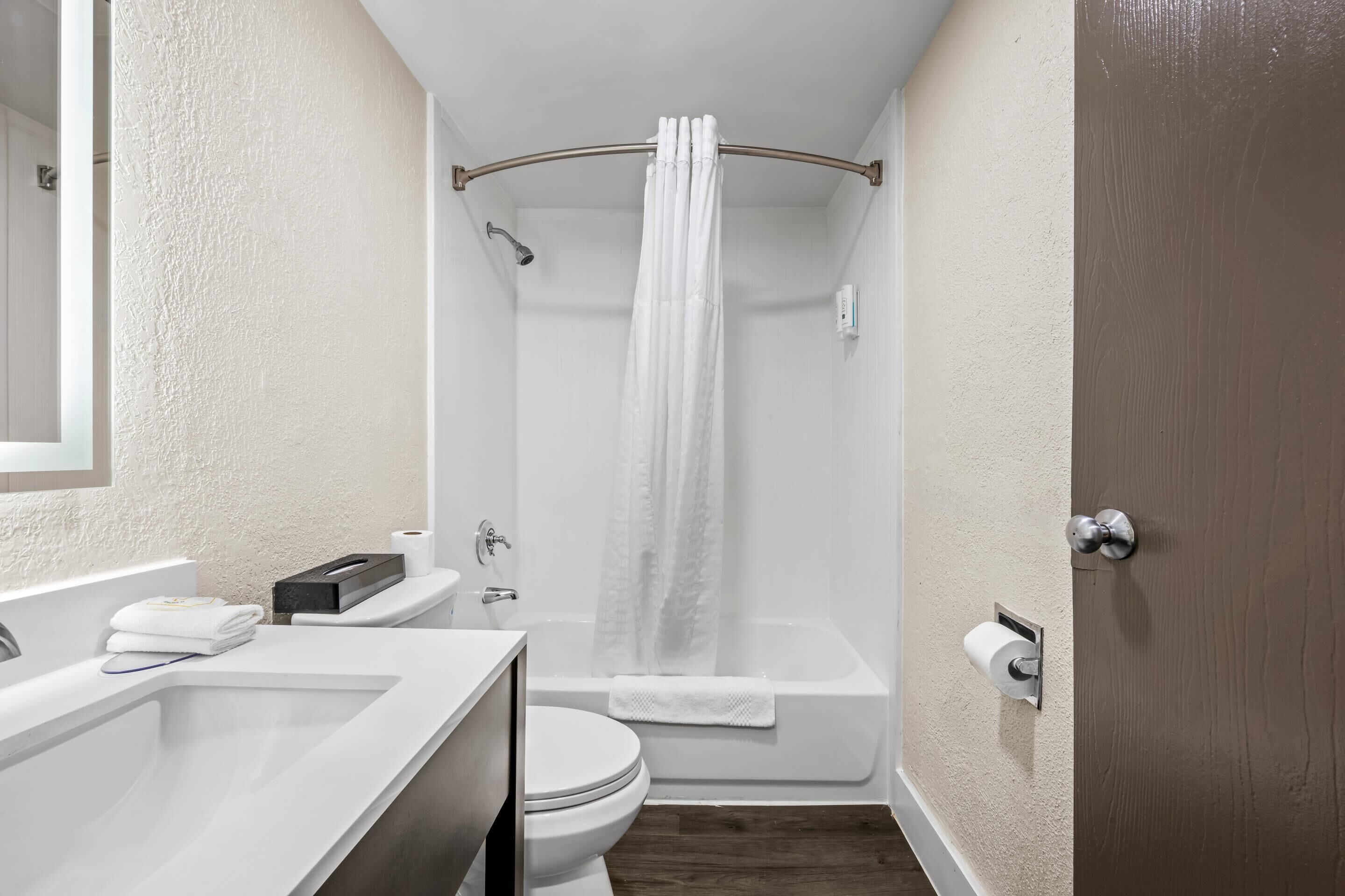 A bathroom with a bathtub, toilet, and sink.