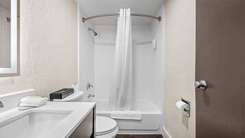 A bathroom with a bathtub, toilet, and sink.