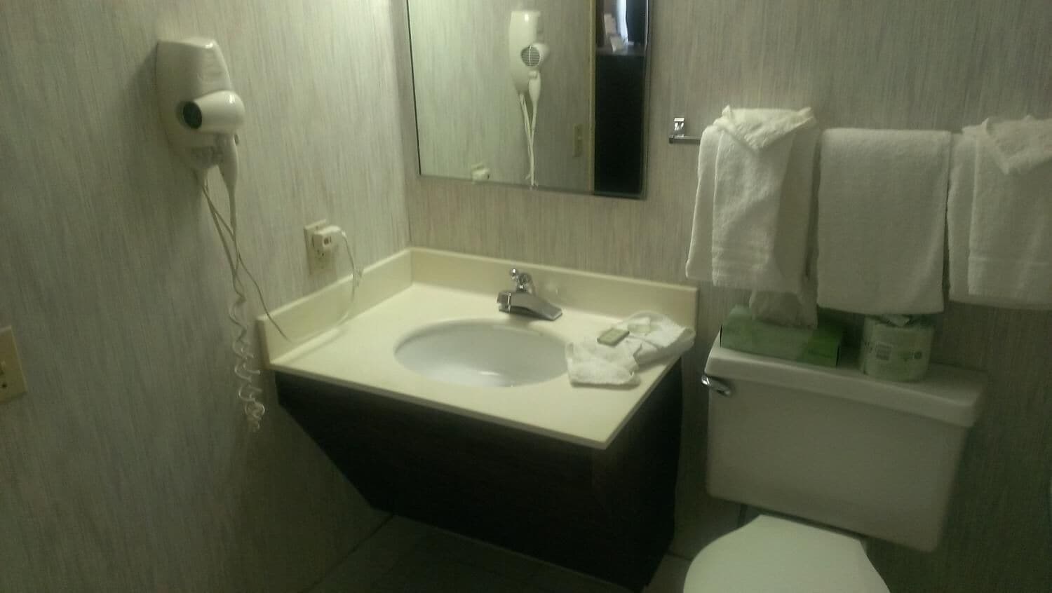 Une salle de bain équipée d’un lavabo, d’un miroir, d’un porte-serviettes et de toilettes.