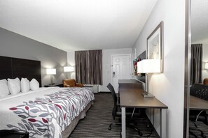 A hotel room with a bed, desk, chair, and a mirror. - Red Roof Inn Defuniak Springs (De Funiak Springs)