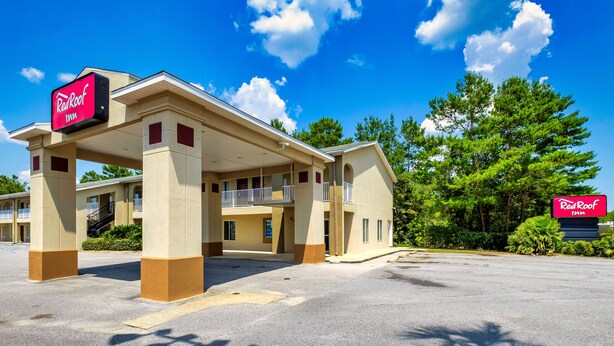 A Red Roof Inn with a covered parking area and a clear blue sky. - Red Roof Inn Defuniak Springs (De Funiak Springs)