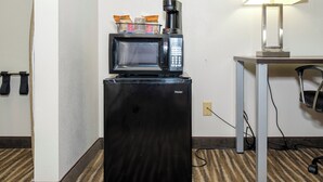 A compact kitchenette with a black refrigerator, a microwave, and a coffee maker on top. - Red Roof Inn Defuniak Springs (De Funiak Springs)