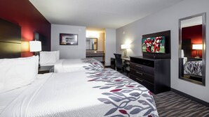 A hotel room with a bed, a desk, a chair, a TV, and a mirror. - Red Roof Inn Defuniak Springs (De Funiak Springs)