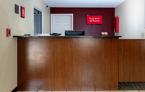 Un comptoir d’accueil doté d’un écran numérique affichant la mention : « Wi-Fi gratuit dans toutes les chambres ».