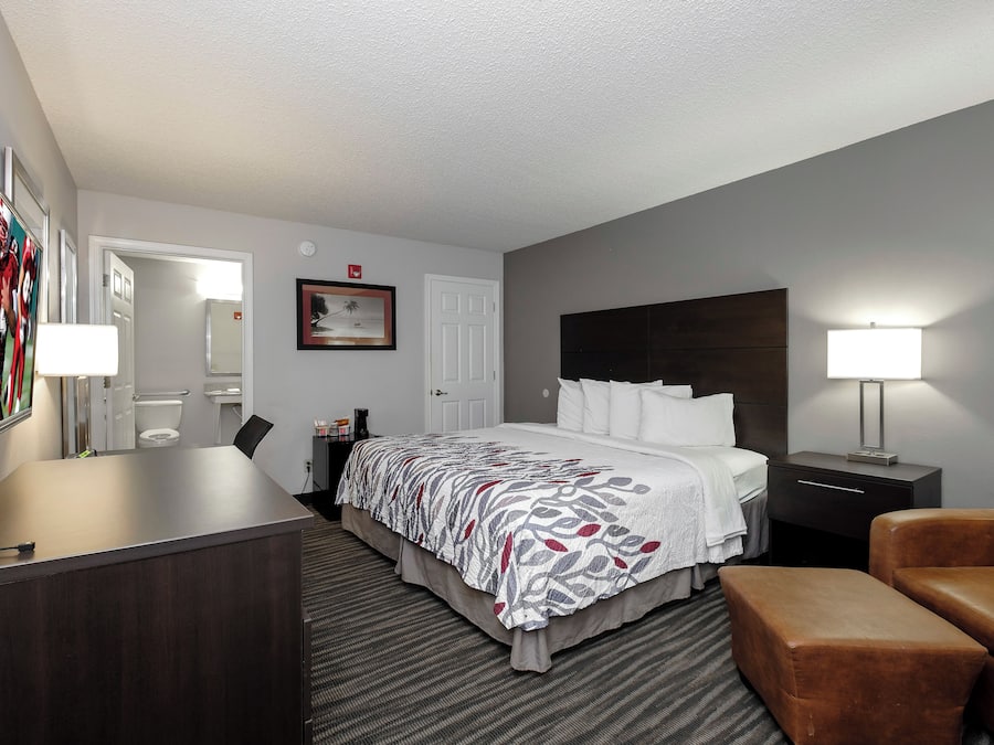 Habitación de hotel con cama, mesitas de noche, escritorio, silla y televisión.