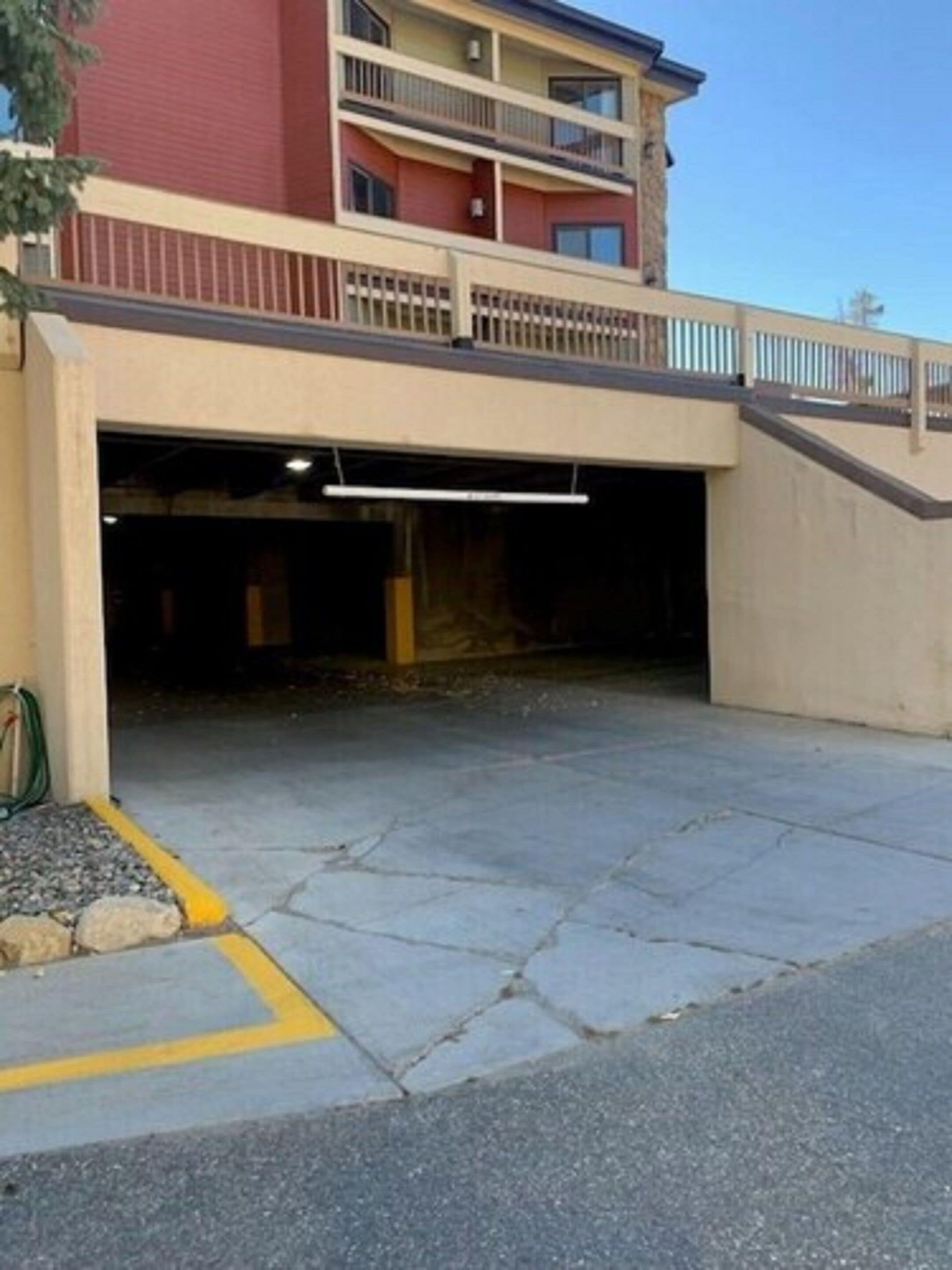 Un edificio a più piani con un'area parcheggio coperta.