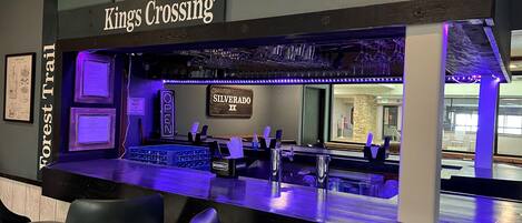 A bar area with a sign reading "Kings Crossing" and "Forest Trail".