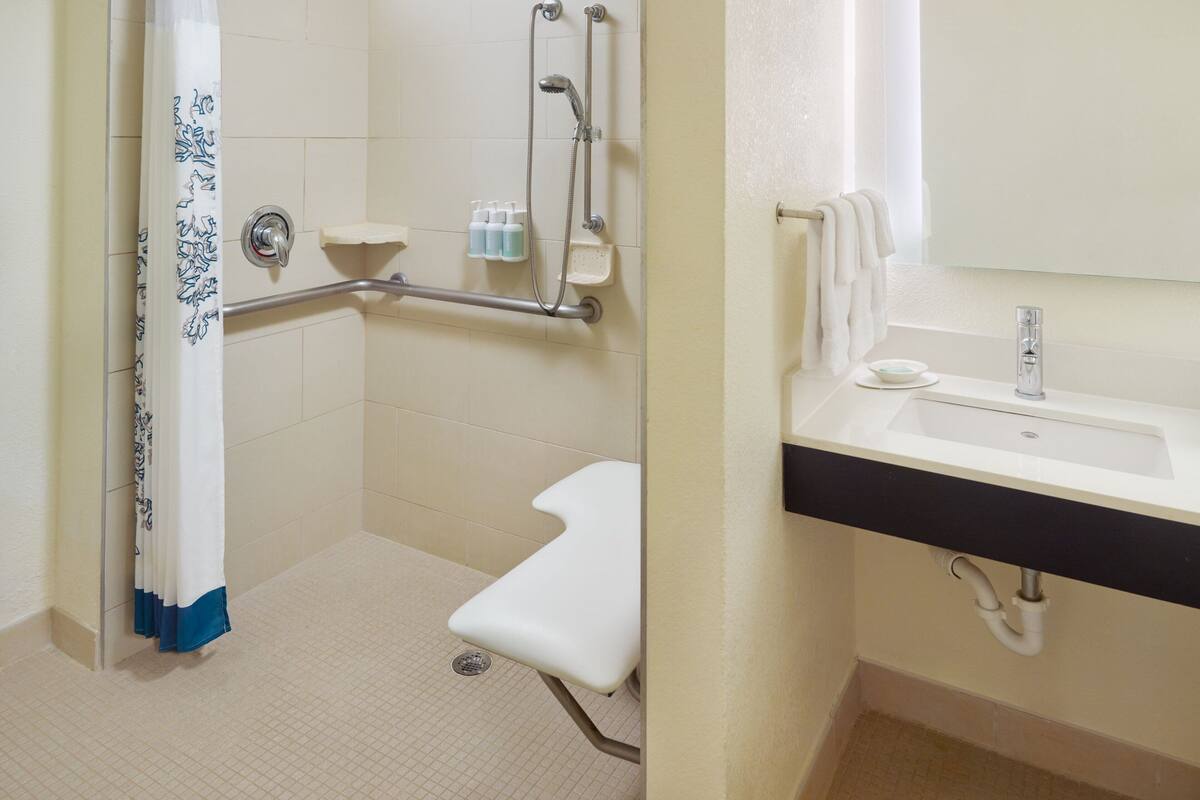 A bathroom with a shower, toilet, and sink.