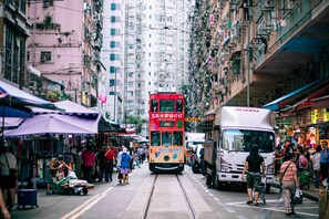 A crowded street with a tram and a white truck. - ibis Hong Kong North Point (Hong Kong)