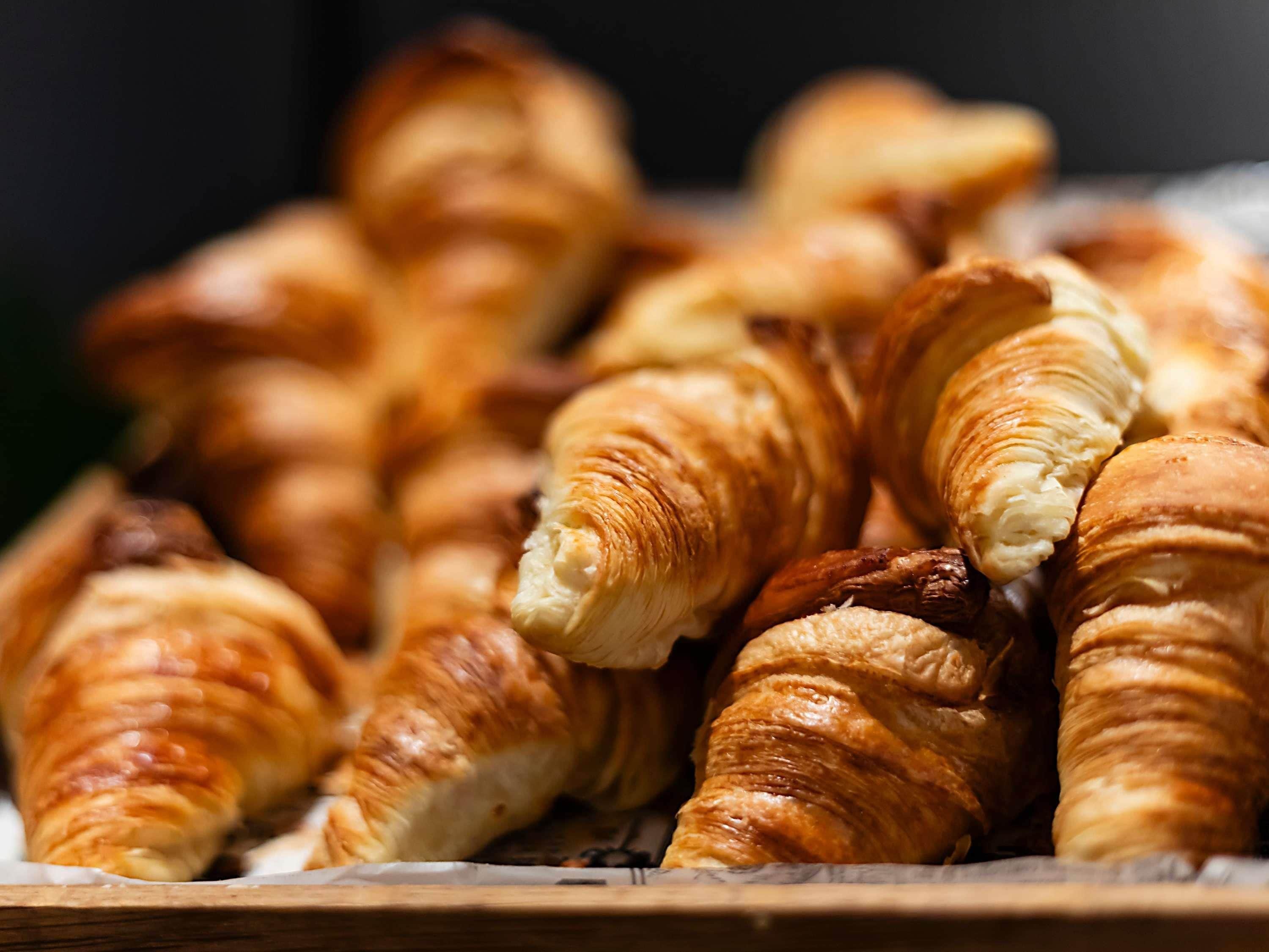 Un plateau en bois contenant plusieurs croissants de couleur brun doré.