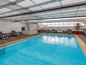 Una piscina techada, sillones reclinables de piscina
