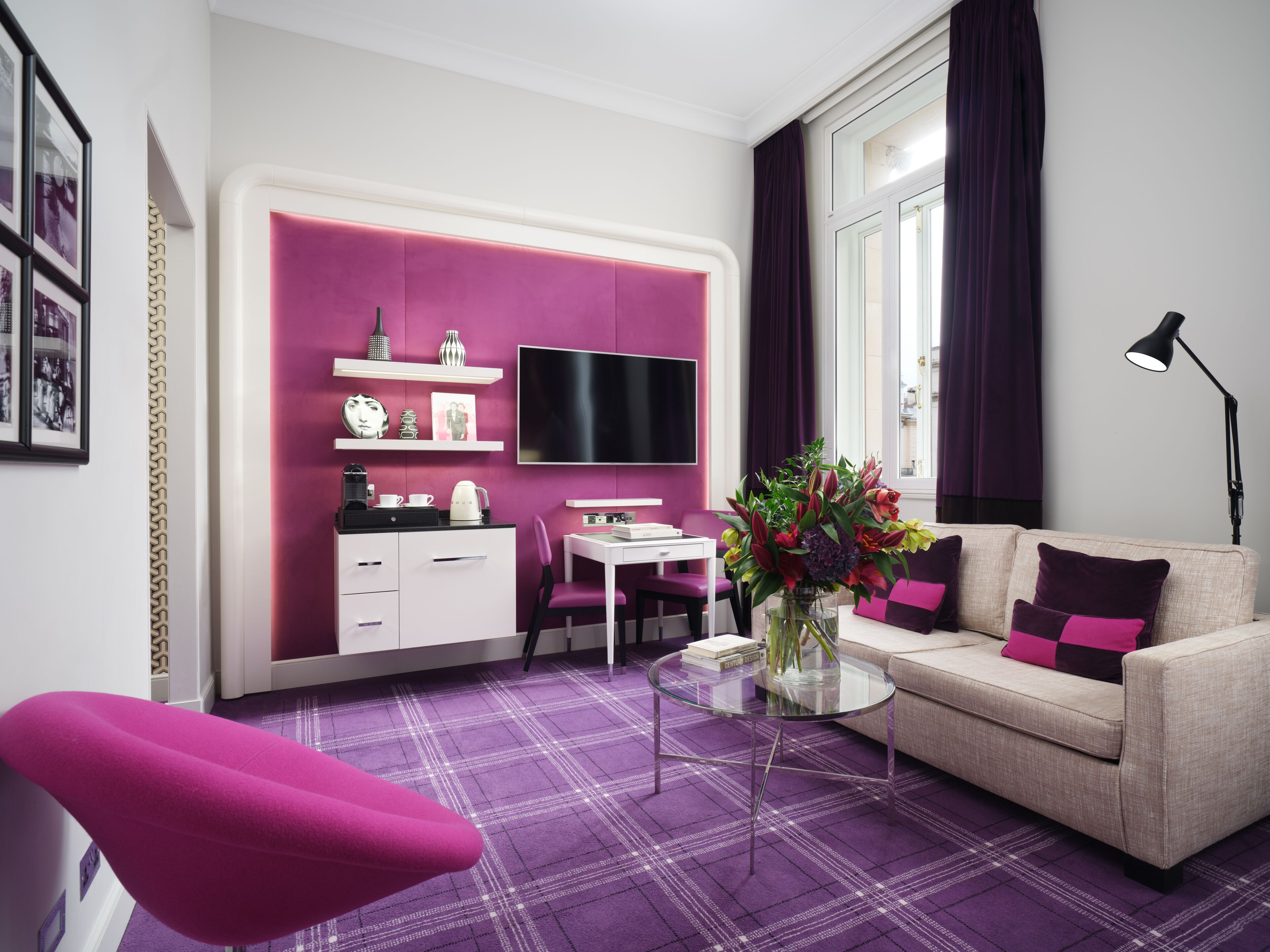 A modern living room with a sofa, a coffee table, a TV, and a desk.