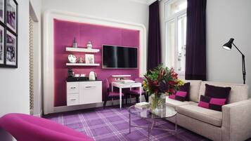 A modern living room with a sofa, a coffee table, a TV, and a desk.