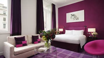 Una habitación de hotel con una cama, un sofá, una mesita de centro y una silla.