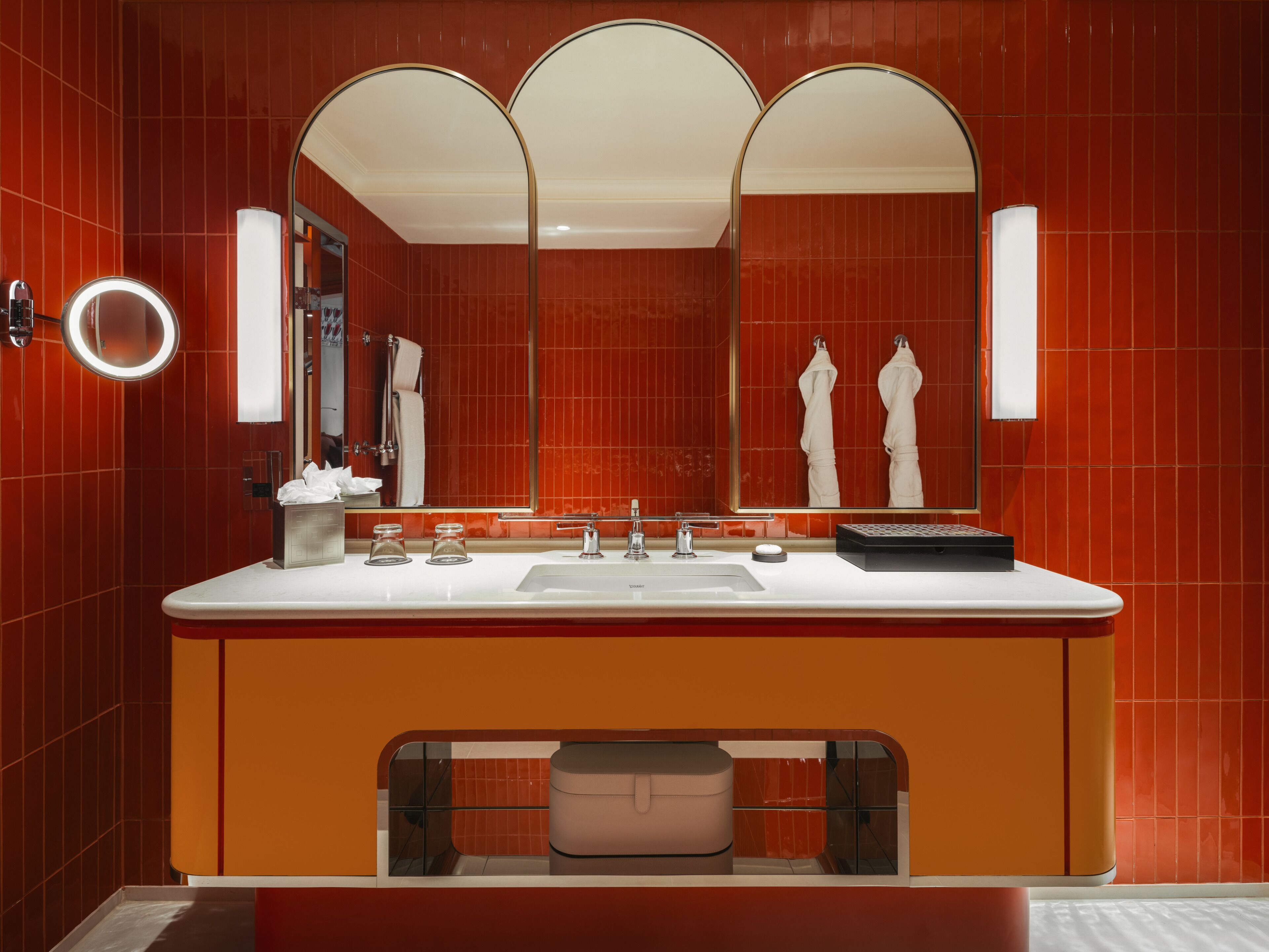Un baño moderno con un espejo grande, dos lavamanos y un mueble de tocador con un armario de almacenamiento.