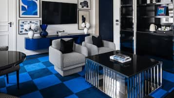 Una sala moderna con sofás estampados de cuadros, una mesa de centro negra y un suelo también a cuadros en tono azul.