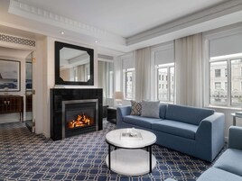 A modern living room with a fireplace, a blue sofa, and a round coffee table.