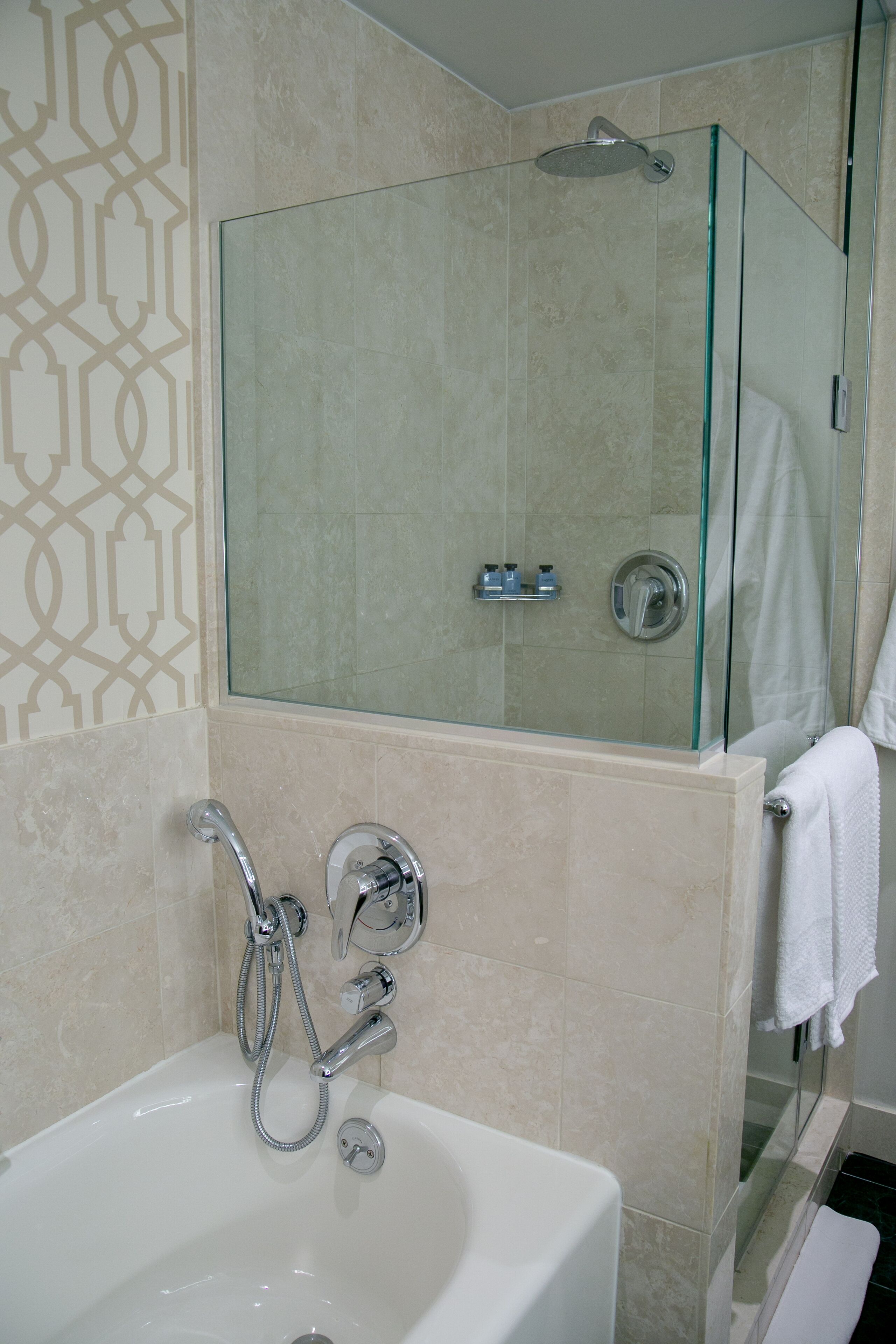 A modern bathroom with a glass-enclosed shower, a standalone bathtub, and a glass shower door.