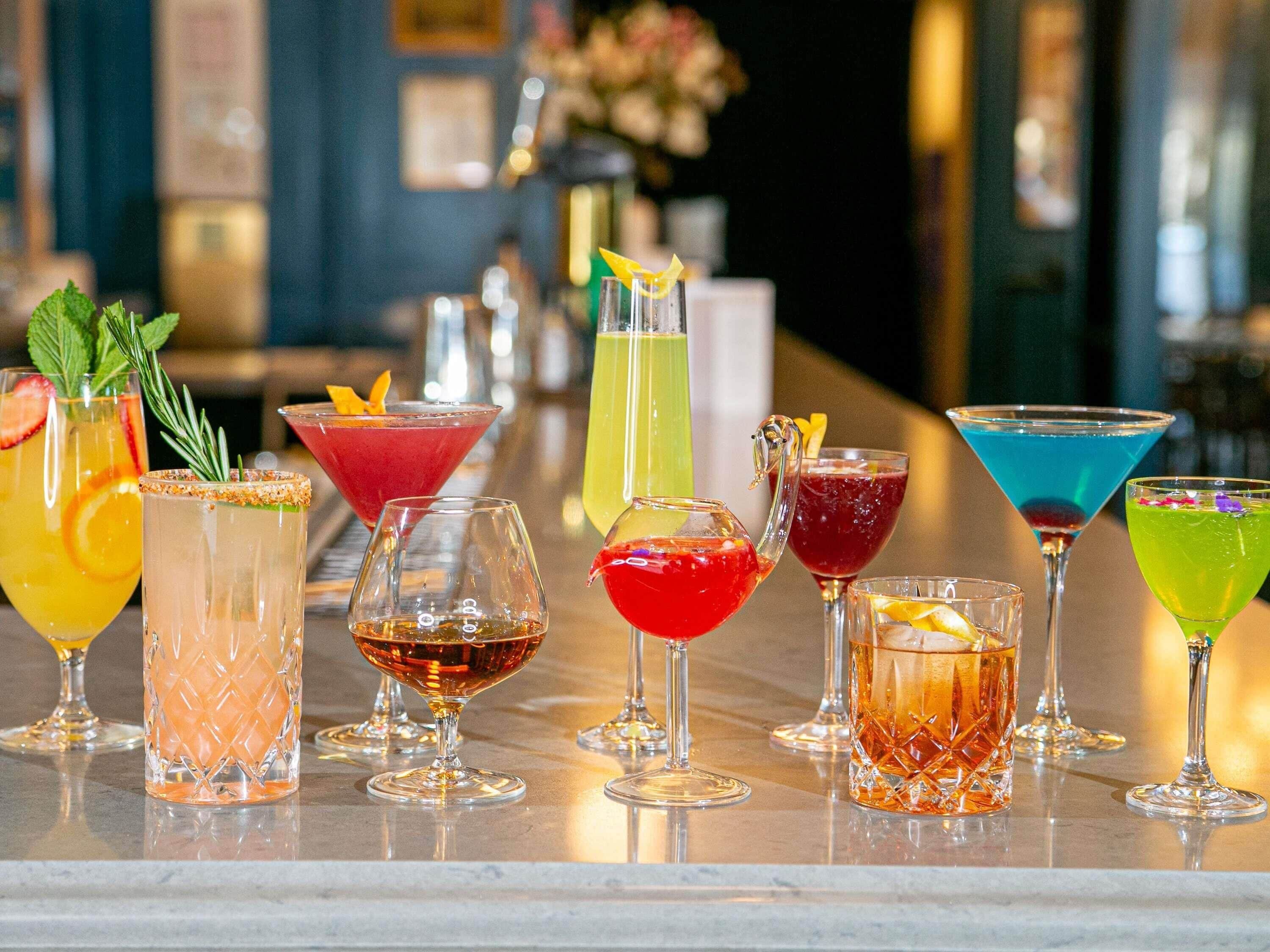 Un bar proposant une variété de cocktails colorés, servis dans différents types de verres.