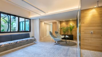 A modern interior with a seating area, a plant, and a wooden accent wall.