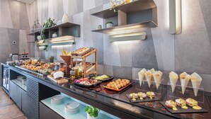 A buffet with various food items and a clock on the wall.