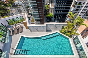 Una piscina al aire libre, sillones reclinables de piscina