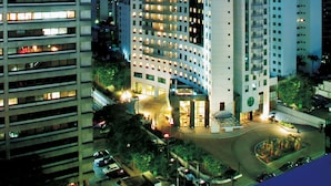 A high-rise building with multiple floors, large windows, and a prominent corner entrance.