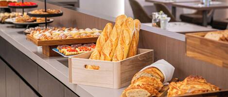 A buffet counter with various baked goods and pastries.