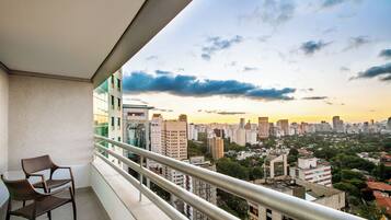 Un balcón con vista a un paisaje urbano al atardecer.