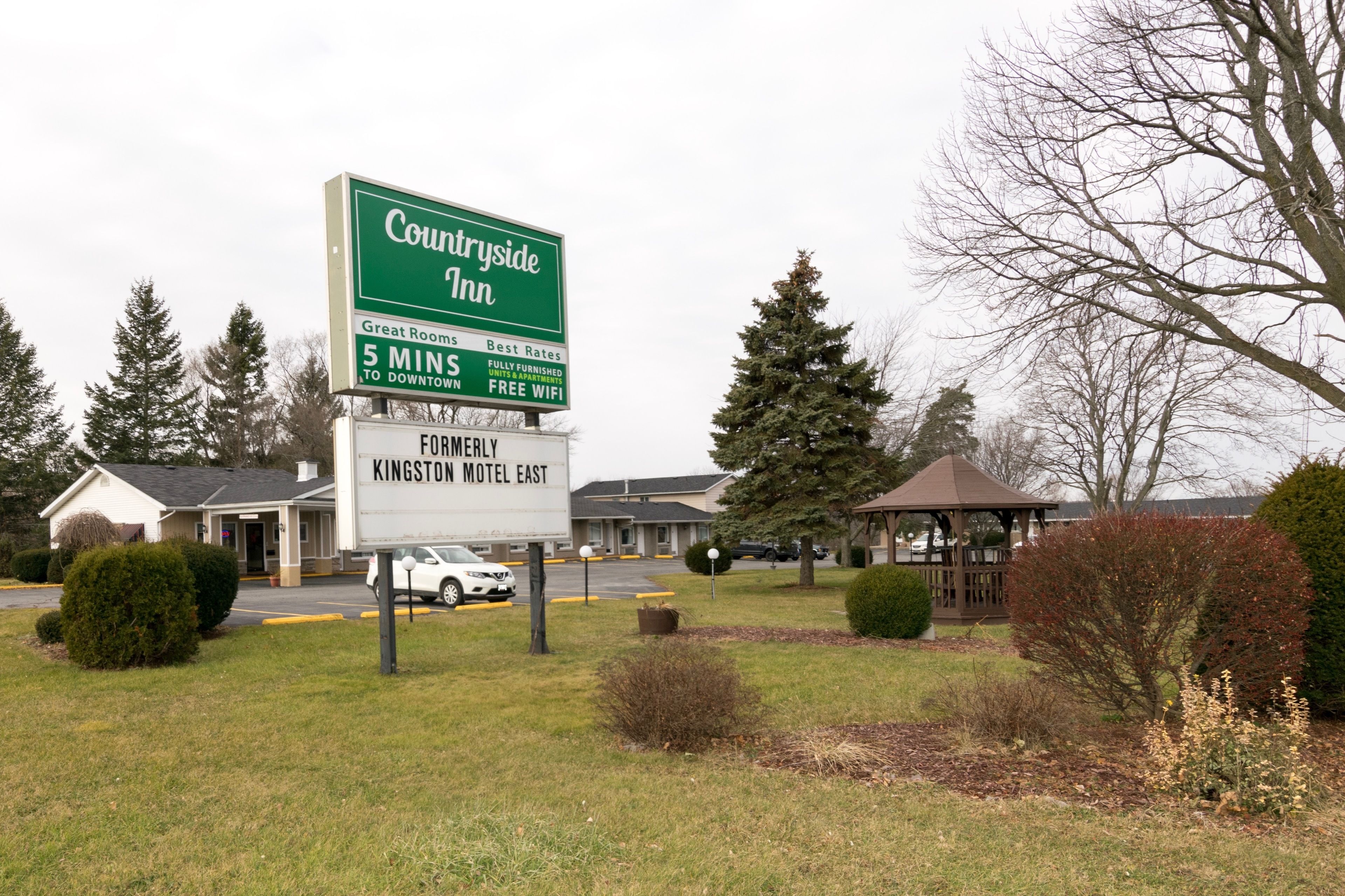 Skilt for et landlig hotel med Country Inn logo, 5 minutters kørsel til centrum, samt et skilt for Kingston Motel East.