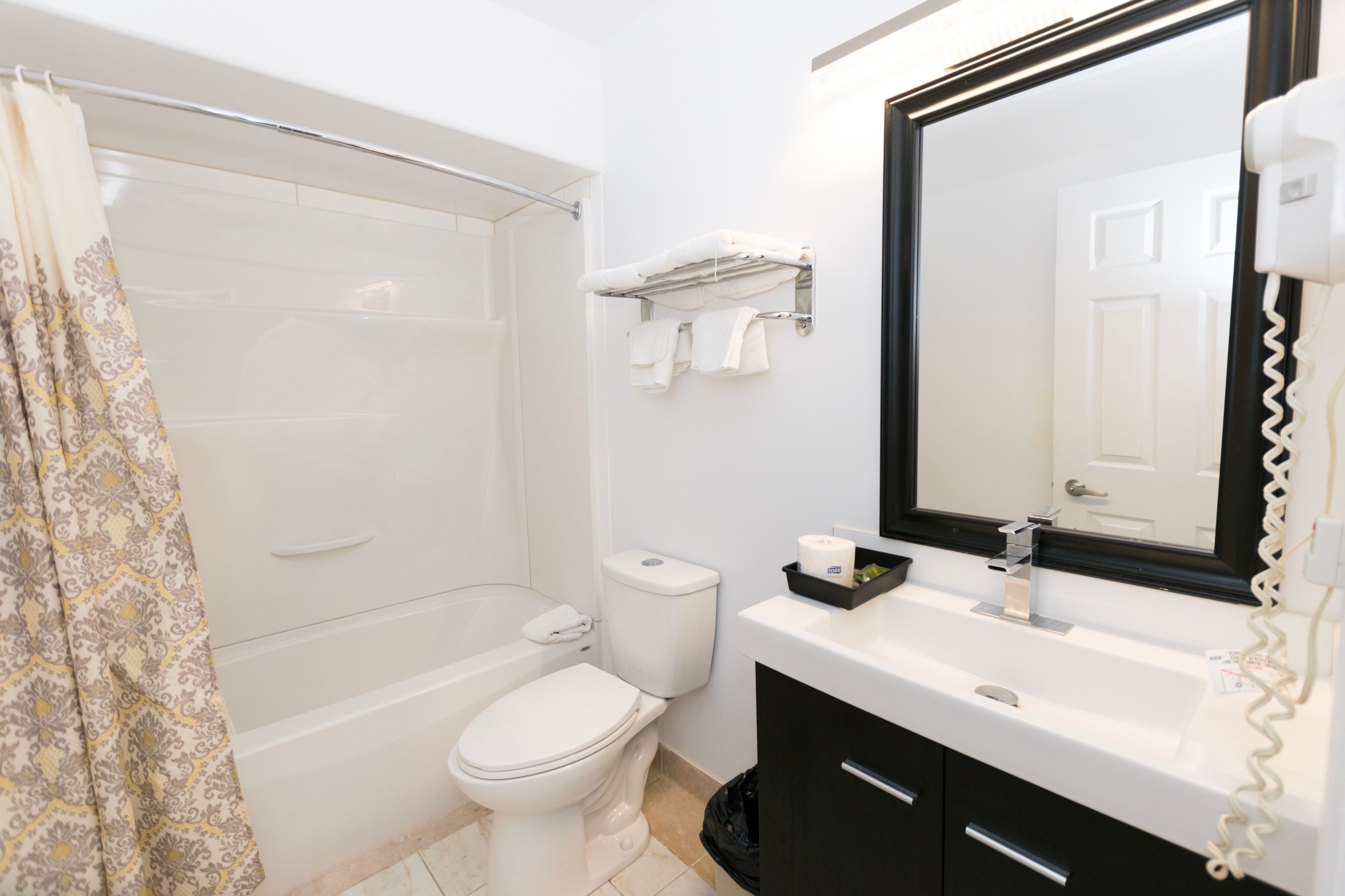 A bathroom with a bathtub, toilet, and sink.