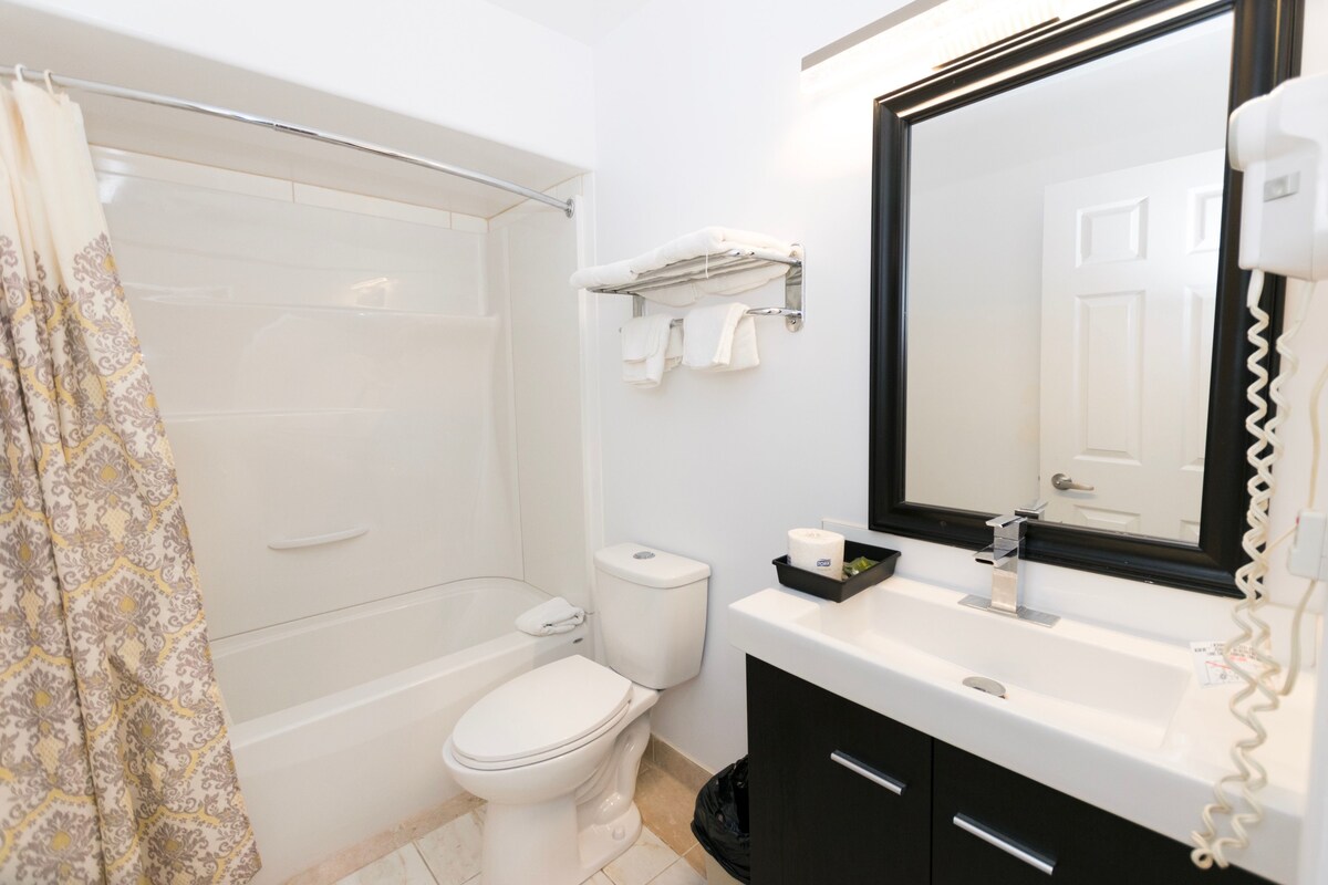 A bathroom with a bathtub, toilet, and sink.