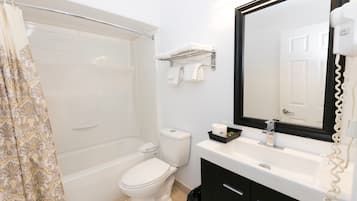 A bathroom with a bathtub, toilet, and sink.