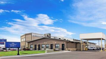 A Howard Johnson hotel with a parking lot, a gas station, and a clear blue sky.