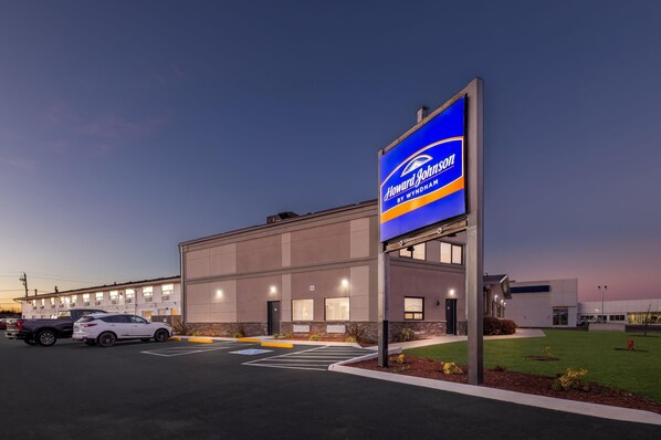 A Howard Johnson's by Wyndham hotel with a modern facade, parking lot, and well-lit exterior.